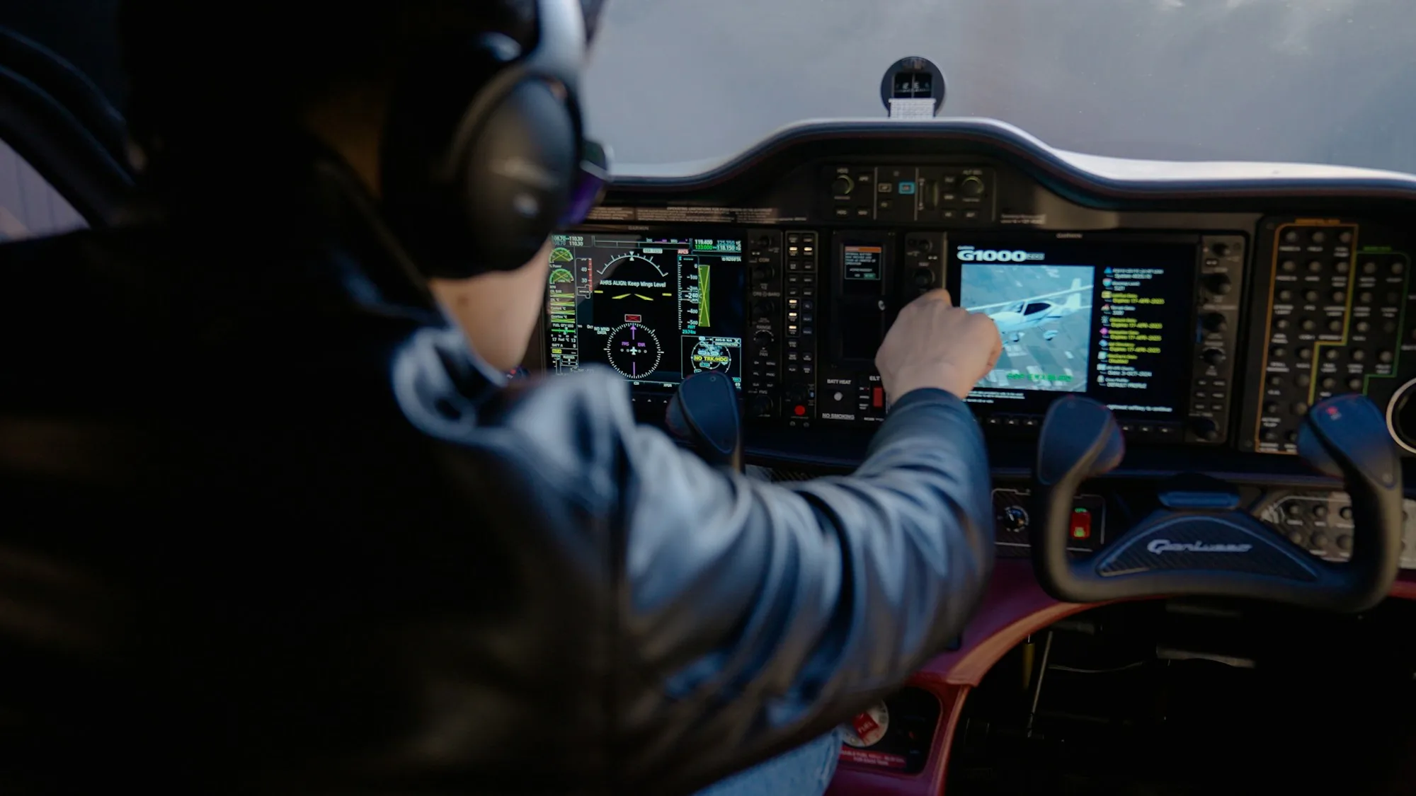 Pilot using a touchscreen navigation display beside aircraft controls